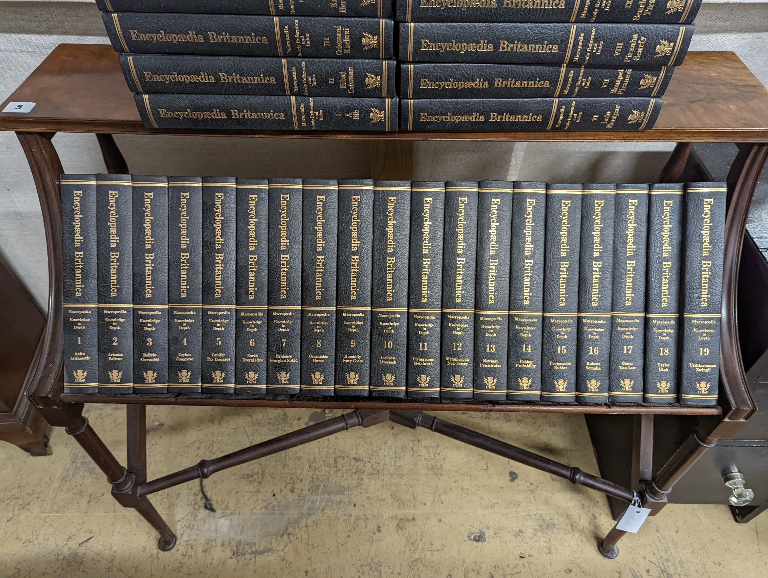 A Liberty style mahogany book stand, together with a set of the Encyclopedia Britannica, width 91cm, depth 39cm, height 84cm